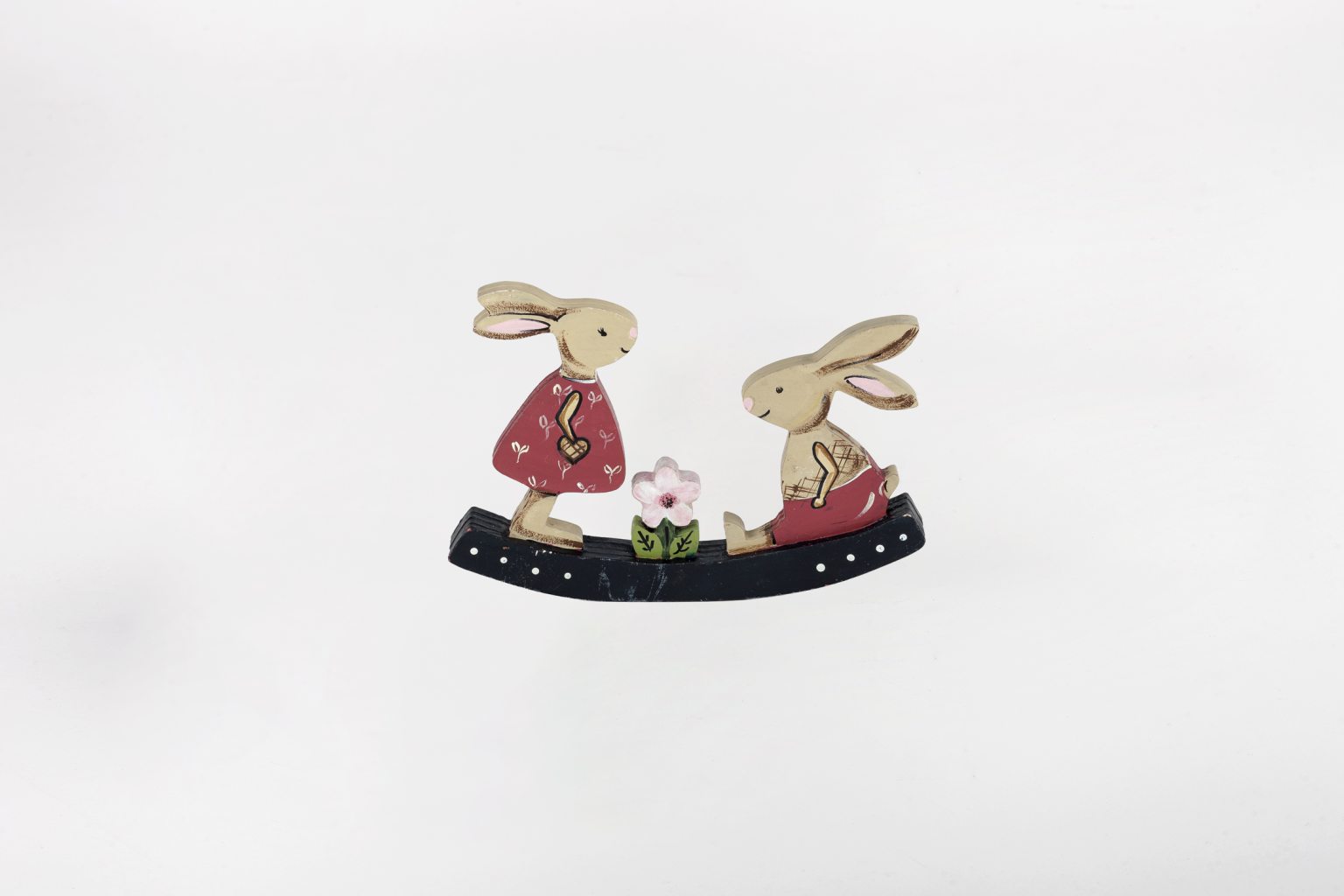 Handmade wooden rabbits on a seesaw