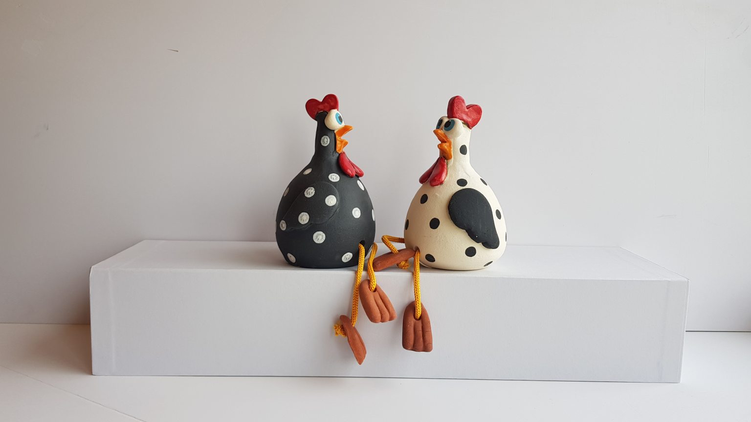 Two black and white handmade ceramic chickens