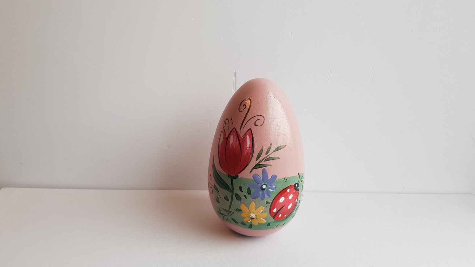 Œuf en bois rose peint à la main avec coccinelle et fleurs