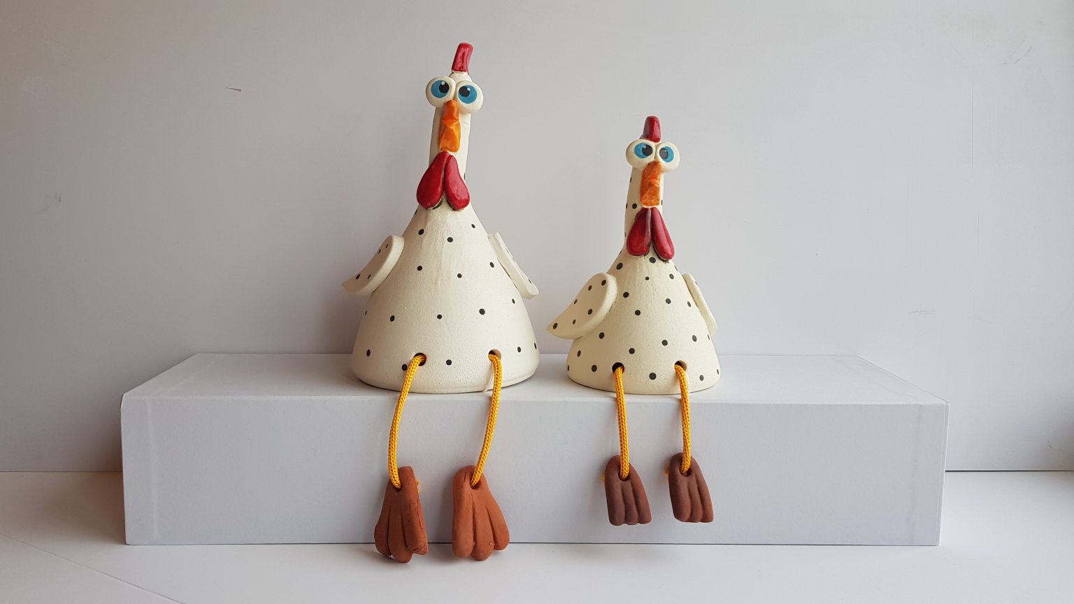 Two large white handmade ceramic chickens